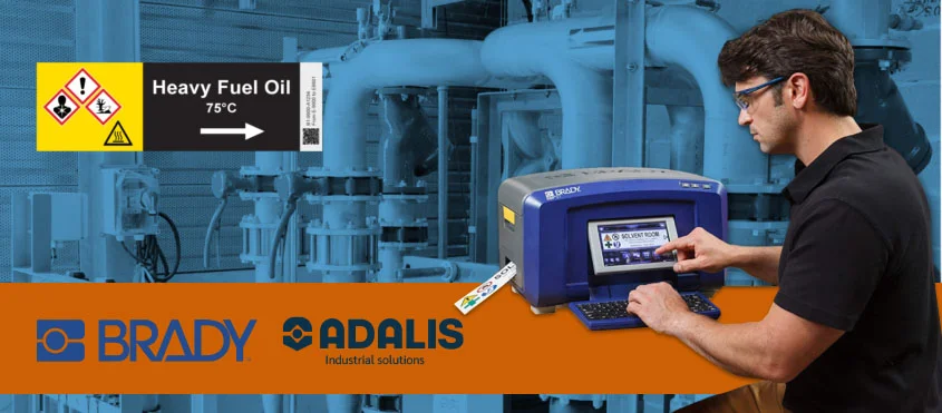 Man using Brady industrial label printer to create chemical safety labels in a mechanical facility